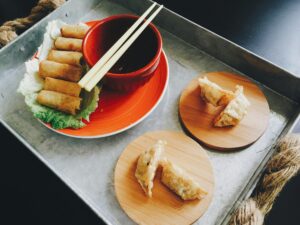 Appetizing Asian dumplings on bamboo plates with chopsticks and soy dipping sauce.